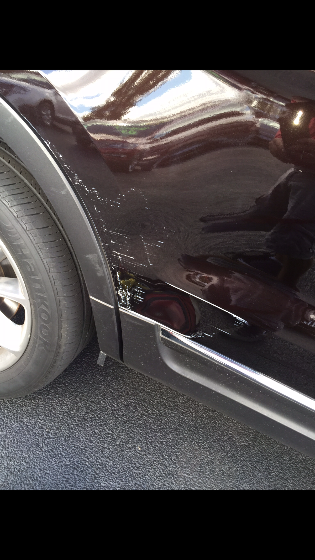Before repair on black vehicle quarter panel with visible scuffs