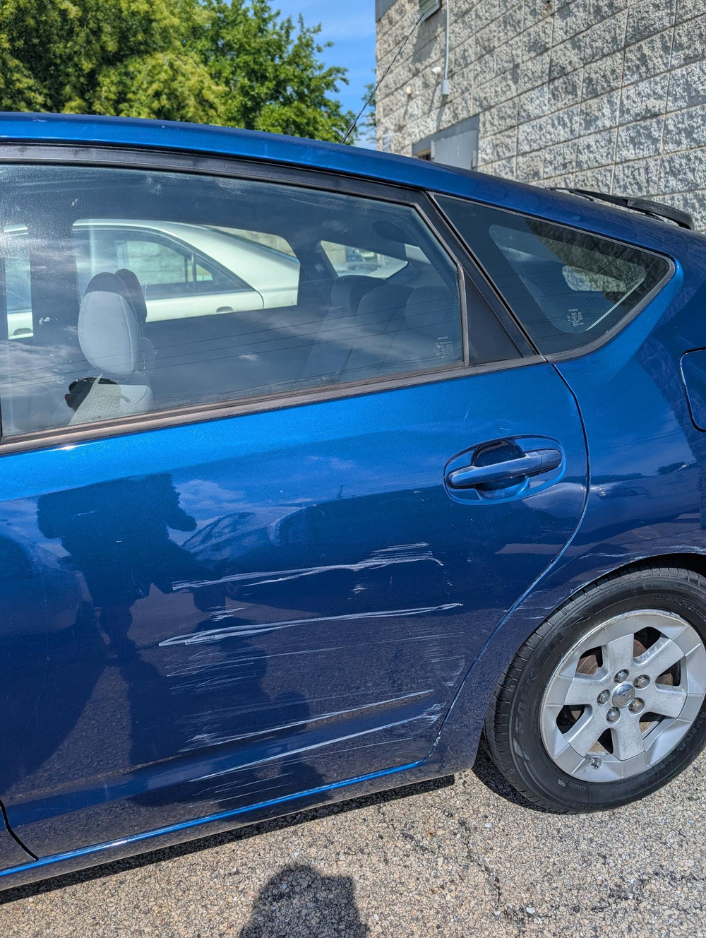Before door scuff repair on blue Prius